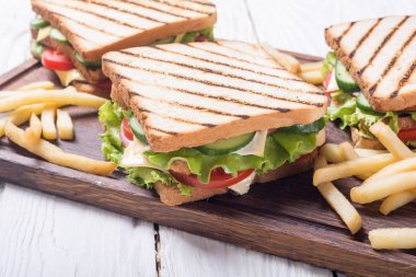 Domates, salatalık, jambon, peynir ve salata ile kulüp sandviç. Clubsandwich