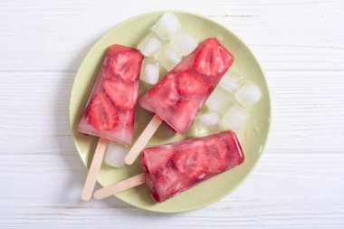 Çilek ile ev yapımı çubuklu dondurmayı. Suyu donmuş yaz
