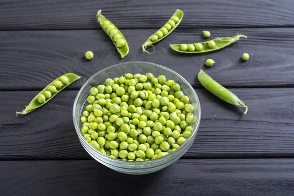 Healthy food . Green peas in bowl on wooden background