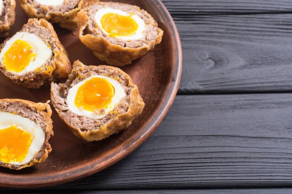 homemade scotch eggs on rustic wooden background