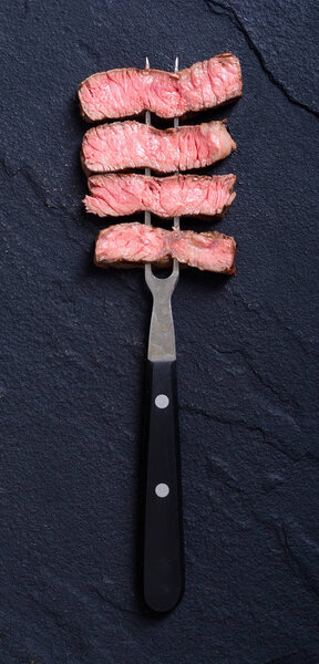 Рибай из говяжьего стейка на мясной вилке

