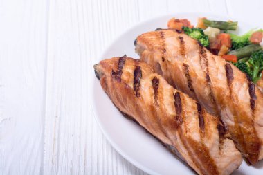 Bir tabakta sebze ile ızgara somon balık. Deniz ürünleri