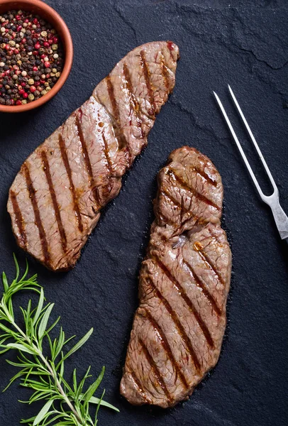 Grilovaný Hovězí Steak Rustikální Kamenné Pozadí Rozmarýnem Pepřem — Stock fotografie