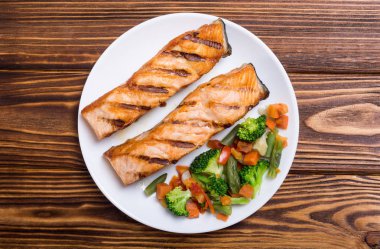 Bir tabakta sebze ile ızgara somon balık. Deniz ürünleri