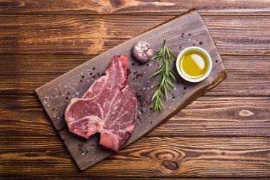 Madde ile ham sığır eti biftek T kemik. Porterhouse kesme tahtası üzerinde .