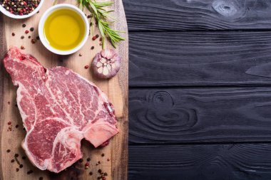 Madde ile ham sığır eti biftek T kemik. Porterhouse kesme tahtası üzerinde .