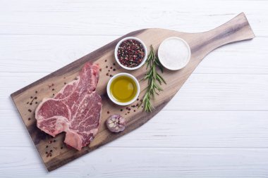 Madde ile ham sığır eti biftek T kemik. Porterhouse kesme tahtası üzerinde .