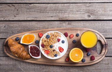 Yoğurt, granola, çilek, portakal suyu, kruvasan ve reçel kahvaltı