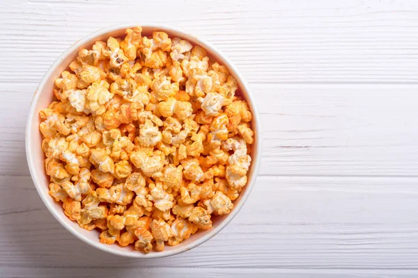 Yellow cheese popcorn in bowl . Snack for cinema