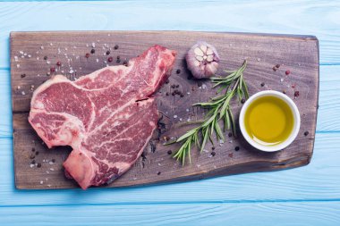 Madde ile ham sığır eti biftek T kemik. Porterhouse kesme tahtası üzerinde .