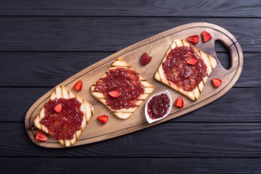Rustik ahşap zemin üzerine çilek reçeli ile tost