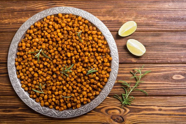 Roasted chickpeas with rosemary . Snack baked food .