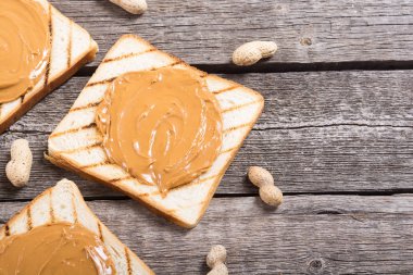 Fıstık ezmeli sandviç ya da ahşap arka planda tost.