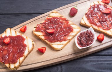 Rustik ahşap zemin üzerine çilek reçeli ile tost