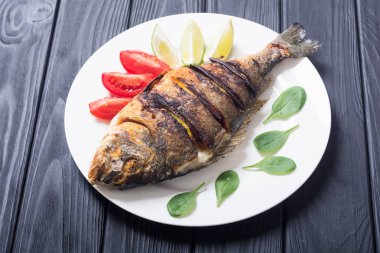 Kızarmış balık dorado limon, domates ve ıspanak ile. Deniz gıda arka plan