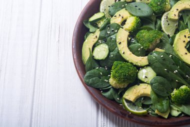 Yeşil bebek ıspanak salatası avokado, brokoli, salatalık, kireç ve susam. Sağlıklı detoks vegan gıda