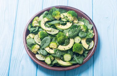 Yeşil bebek ıspanak salatası avokado, brokoli, salatalık, kireç ve susam. Sağlıklı detoks vegan gıda