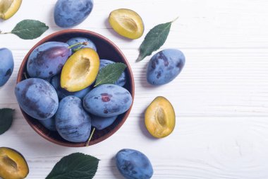 Ahşap masa üzerinde kase taze erik. Meyve arka plan