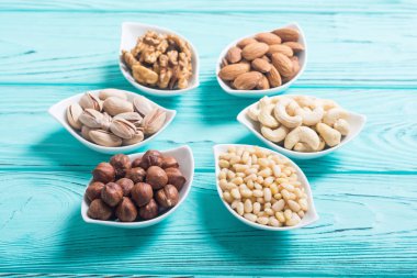 Fındık karışımı: antep fıstığı, badem, ceviz, çam fıstığı, fındık ve kaju. Kase backgrond içinde snack