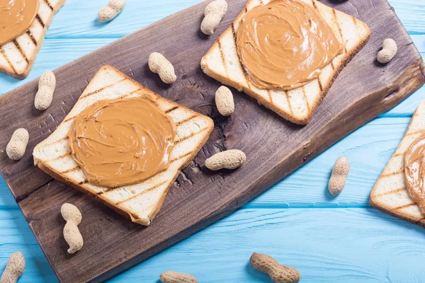 Peanut butter sandwiches or toasts on wooden background