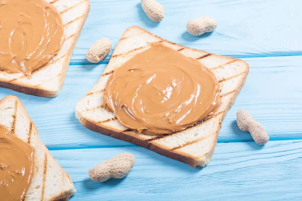 Peanut butter sandwiches or toasts on wooden background