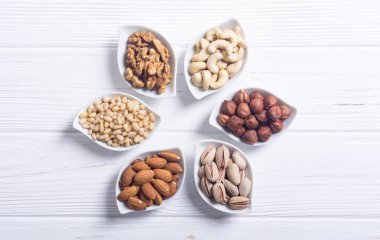 Fındık karışımı: antep fıstığı, badem, ceviz, çam fıstığı, fındık ve kaju. Kase backgrond içinde snack