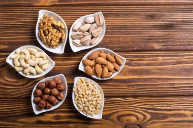 Fındık karışımı: antep fıstığı, badem, ceviz, çam fıstığı, fındık ve kaju. Kase backgrond içinde snack