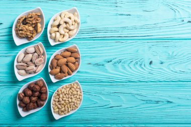 Fındık karışımı: antep fıstığı, badem, ceviz, çam fıstığı, fındık ve kaju. Kase backgrond içinde snack