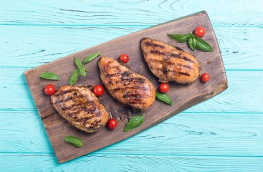 Izgara tavuk göğsü (fileto) fesleğen ve domates ile. Barbekü arka plan