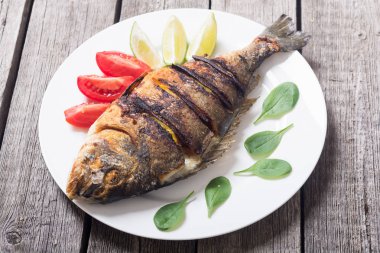 Kızarmış balık dorado limon, domates ve ıspanak ile. Deniz gıda arka plan