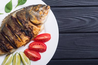 Kızarmış balık dorado limon, domates ve ıspanak ile. Deniz gıda arka plan