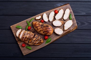 Izgara tavuk göğsü (fileto) fesleğen ve domates ile. Barbekü arka plan