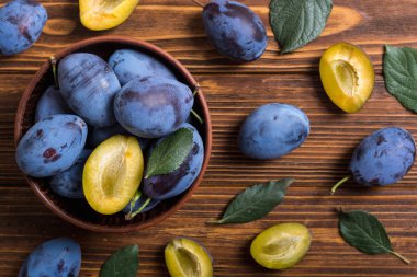 Ahşap masa üzerinde kase taze erik. Meyve arka plan