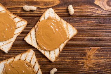 Fıstık ezmeli sandviç ya da ahşap arka planda tost.