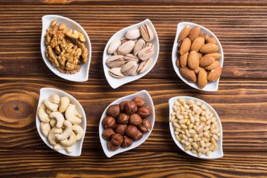 Fındık karışımı: antep fıstığı, badem, ceviz, çam fıstığı, fındık ve kaju. Kase backgrond içinde snack