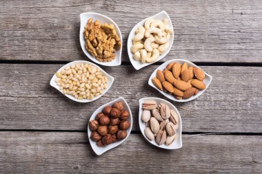 Fındık karışımı: antep fıstığı, badem, ceviz, çam fıstığı, fındık ve kaju. Kase backgrond içinde snack