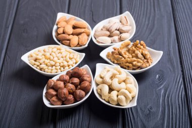 Fındık karışımı: antep fıstığı, badem, ceviz, çam fıstığı, fındık ve kaju. Kase backgrond içinde snack