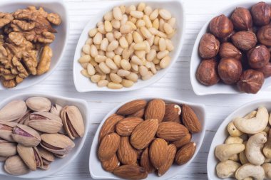 Fındık karışımı: antep fıstığı, badem, ceviz, çam fıstığı, fındık ve kaju. Kase backgrond içinde snack