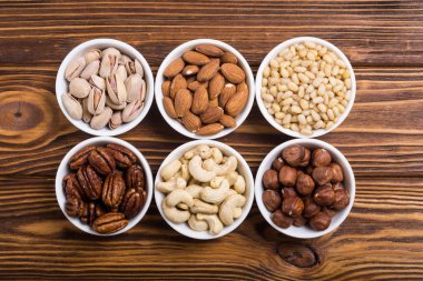 Fındık karışımı: antep fıstığı, badem, ceviz, çam fıstığı, fındık ve kaju. Kase backgrond içinde snack