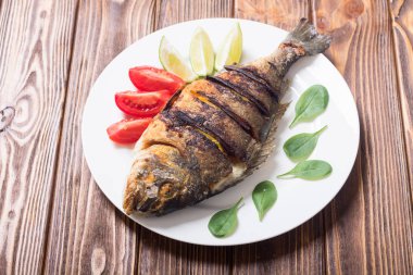 Kızarmış balık dorado limon, domates ve ıspanak ile. Deniz gıda arka plan