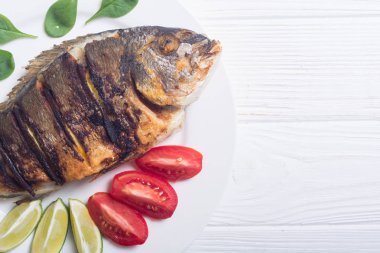 Kızarmış balık dorado limon, domates ve ıspanak ile. Deniz gıda arka plan