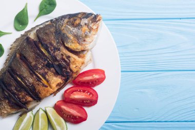 Kızarmış balık dorado limon, domates ve ıspanak ile. Deniz gıda arka plan