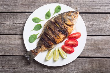 Kızarmış balık dorado limon, domates ve ıspanak ile. Deniz gıda arka plan