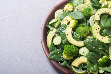 Yeşil bebek ıspanak salatası avokado, brokoli, salatalık, kireç ve susam. Sağlıklı detoks vegan gıda