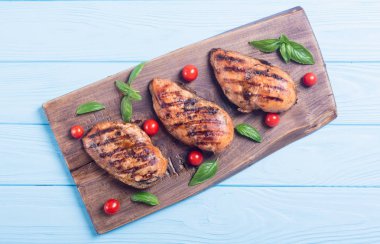 Izgara tavuk göğsü (fileto) fesleğen ve domates ile. Barbekü arka plan