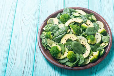 Yeşil bebek ıspanak salatası avokado, brokoli, salatalık, kireç ve susam. Sağlıklı detoks vegan gıda