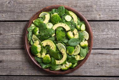 Yeşil bebek ıspanak salatası avokado, brokoli, salatalık, kireç ve susam. Sağlıklı detoks vegan gıda