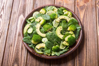 Yeşil bebek ıspanak salatası avokado, brokoli, salatalık, kireç ve susam. Sağlıklı detoks vegan gıda