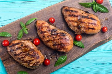 Izgara tavuk göğsü (fileto) fesleğen ve domates ile. Barbekü arka plan