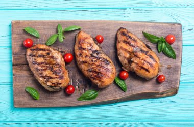 Izgara tavuk göğsü (fileto) fesleğen ve domates ile. Barbekü arka plan